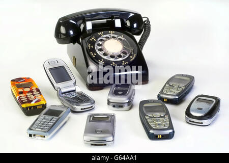 Old working cell phones and black rotary telephone. Stock Photo