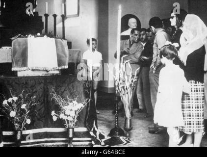 In a plain wooden packing case, the remains of Benito Mussolini, one-time dictator of Fascist Italy. His body lies in state in a private chapel at San Cassiano cemetery before burial in the family tomb. Mussolini's body had been hidden for 10 years before in a hiding place known only to two men. This weekend, his body was returned to his widow. The former Il Duce and his mistress, Clara Petacci, were hanged by partisans when escaping after his regime had collapsed during the Second World War. Stock Photo