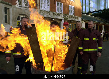 Firefighters from Blue and Green watches at Euston Fire Station in London stand in front of a brazier after coming out on strike, at the start of eight days of inductrial action over a pay dispute. * Unions and employers were in contact throughout the night in an attempt to stop the strike. Stock Photo