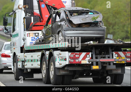 The grey Renault Clio is removed from the scene on the A419 near Swindon, after it careered off the road into undergrowth. A teenage driver and her female passenger have died in the accident and three men are in hospital. Stock Photo