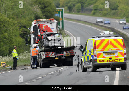 The grey Renault Clio is removed from the scene on the A419 near Swindon, after it careered off the road into undergrowth. A teenage driver and her female passenger have died in the accident and three men are in hospital. Stock Photo