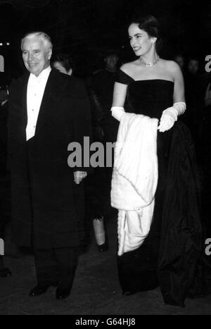 Charlie Chaplin and his wife, Oona - with a fur cape over her arm - arrive for the Royal Film Show at the Empire Theatre, Leicester Square. Chaplin was to make an appearance in the stage show before the Queen and other members of the Royal Family. Stock Photo