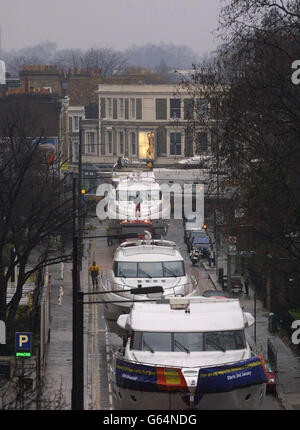 Boats on the back of flat-bed lorries makes their way up Lillie Road in London towards Earls Court exhibition centre. The venue is hosting the forthcoming London Boat Show which begins on January 2. Stock Photo