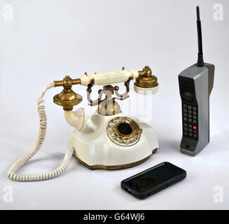 Working smart cell phone and old white rotary telephone. Stock Photo