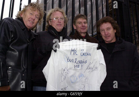 Giving the shirt of their backs' rock musicians (l-r) singer and song writer for Bad Company, Robert Hart, bass player in Foreigner, Rick Wills, guitarist who played with Rod Stewart, Gary Grainger and drummer with The Small Faces and The Who, Kenney Jones. * .. stand outside Downing Street in central London, where they were criticising the tax policies of the Chancellor of the Exchequer Gordon Brown. Kenney and Robert have written a song entitled 'You are robbing me Mr Brown' which they penned during the fuel protests drawing on what they were hearing from the general public. Stock Photo