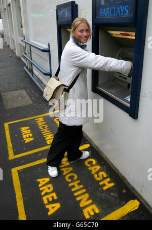 Laura Perkins uses a cash machine at Barclays bank, Grosvenor Street, Manchester where boxes have been painted on the ground to stop people queing too close and prevent muggings. The innovative new scheme in Manchester, gives people their own personal space when withdrawing money. Stock Photo