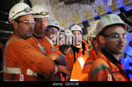 Construction workers watch as London Mayor Boris Johnson marks the breaking through of the 1000 tonne eastern tunnelling machine, named Elizabeth, into Canary Wharf station as work continues on the Crossrail project in London. Stock Photo