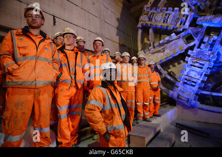 Construction workers watch as London Mayor Boris Johnson marks the breaking through of the 1000 tonne eastern tunnelling machine, named Elizabeth, into Canary Wharf station as work continues on the Crossrail project in London. Stock Photo