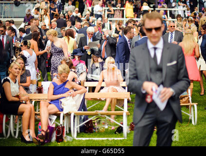 Racegoers enjoy the sun during the Investec Ladies Day at Epsom Downs Racecourse, Surrey. Stock Photo