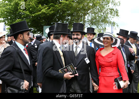Sheikh Mohammed bin Rashid Al Maktoum (centre) with wife Princess Haya bint Al Hussein (right) talks to racing manager John Warren (second left) prior to the Investec Derby Stock Photo
