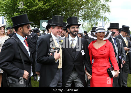 Sheikh Mohammed bin Rashid Al Maktoum (centre) with wife Princess Haya bint Al Hussein (right) talks to racing manager John Warren (second left) prior to the Investec Derby Stock Photo