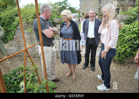 The Duchess of Cornwall speaks with gardener Frank Powell with Pink Floyd drummer Nick Mason and his wife Annette, during a visit to Middlewick House in Pickwick, Wiltshire, the home of Pink Floyd drummer Nick Mason, which is holding a charitable garden open day. Stock Photo