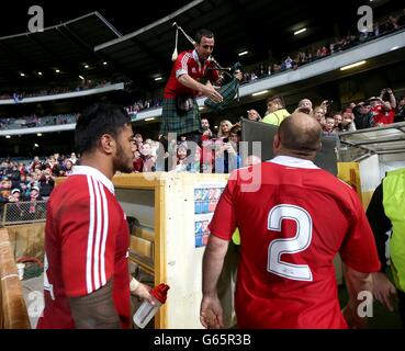 British and Irish Lions' Rory Best (right) is greeted by a man playing bagpipes as they leave the pitch after the final whistle Stock Photo
