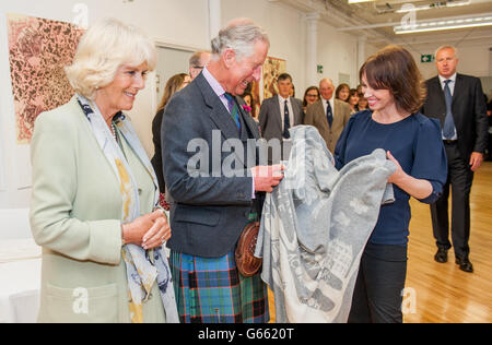 The Prince of Wales and Duchess of Cornwall receive a blanket made for their future grandchild, from Lecturer Emily Quinn, the blanket has the quote 'from little acorns grow mighty oaks', during a visit to the School of Textile and Design at Heriot Watt University in Galashiels. Stock Photo