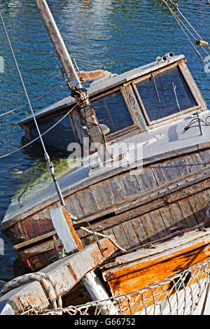 Half submerged small fishing boat in harbor Stock Photo