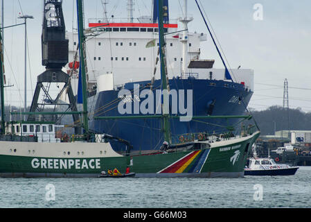 The Greenpeace ship Rainbow Warrior sits anchored across the bows of two MoD cargo vessels loading supplies at Marchwood Military Port. The Greenpeace ship is blockading the British military port in an attempt to stop supply ships from leaving UK waters. *... The vessel is presently in front of the entrance to Marchwood Military port on Southampton Water, where most of the UK's supplies and hardware for a possible war with Iraq is being loaded. 05/02/03 The Ministry of Defence was, expected to urge a High Court judge to extend an injunction banning Greenpeace anti-war protesters from boarding Stock Photo