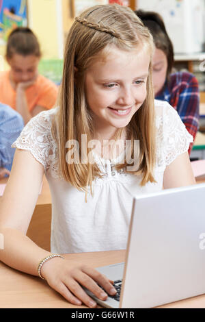 Female Elementary School Pupil Using Laptop In Computer Class Stock Photo