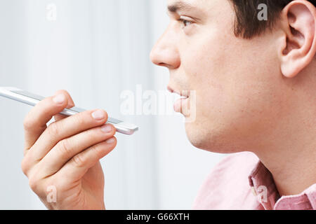 Man Using Internet Voice Search Technology On Mobile Phone Stock Photo