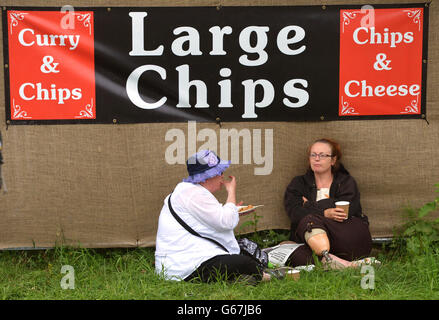 Glastonbury Festival 2013 - Day 2. Festival goers eat meals during the second day of the Glastonbury Festival at Worthy Farm, Somerset. Stock Photo