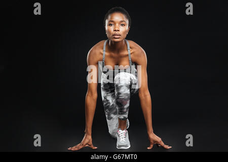 Full length of concentrated beautiful young african american sportswoman over black background Stock Photo