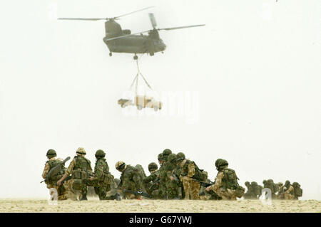 British soldiers of the 51st Sqn Royal Air Force regiment observe a Chinook of the RAF joint helicopter force as it lifts a Land Rover vehicle and its trailer during a practice air assault operation design to capture an enemy airfield, in the desert outside Kuwait City. 07/04/2004: A 'massively botched' procurement has left the RAF with eight Chinook helicopters worth 259 million, which it cannot use, it was revealed Wednesday 7 April 2004. Concerns about cockpit software mean the craft cannot be flown in cloudy weather, said a report by Westminster spending watchdog the National Audit Stock Photo