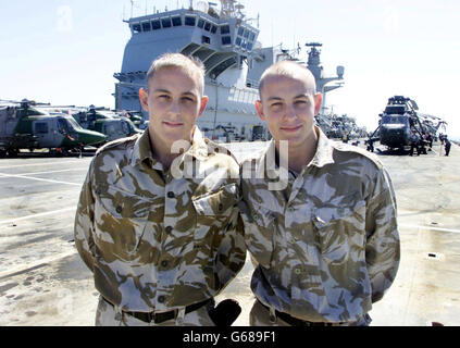 Identical twins Paul (left) and Steven Holland on board HMS Ocean in the Northern Arabian Gulf. By a stroke of chance, the sailor brothers have been stationed with exactly the same individual unit on exactly the same ship for any conflict against Iraq. * Also holding the same job and rank, the twins, from St Helens in Lancashire, both work as Air Engineer Mechanics on navy Sea King helicopters with 845 Naval Air Squadron, currently based on board the helicopter carrier. Stock Photo