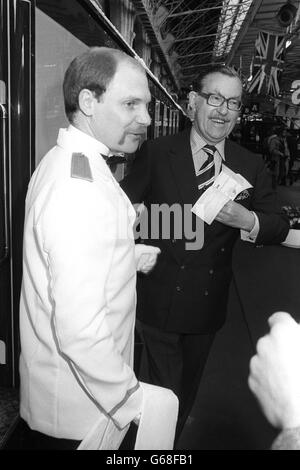 Travel journalist Alan Whicker checks his ticket with a porter before boarding the Venice-Simplon Orient Express, which is leaving from Victoria Station, London, for its inaugural trip. The British section of the journey to Folkestone is in all-Pullman veteran carriages restored to pristine condition. Stock Photo