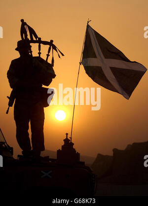 A piper from the Royal Scots Dragoon Guards plays his bagpipes in the Kuwait desert, ahead of possible military action. Stock Photo