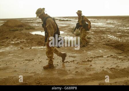 Members of 40 Commando Royal Marines dug in north of the Al Faw Peninsula, aproaching Basra, after heavy rainstorms turned the desert into mud flats. Stock Photo