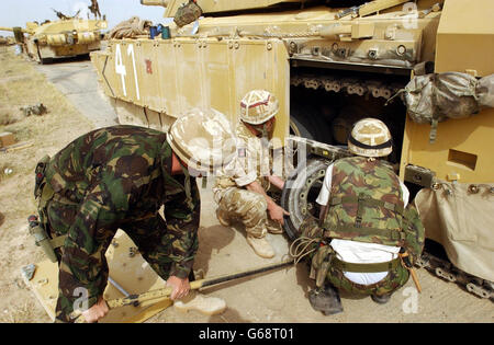 Servicemen from the Royal Scots Dragoon Guards change the wheel on a Challenger II tank near Basra in Iraq. British commanders were trying to establish the extent of the Iraqi opposition in Basra after a night's brief uprising against Saddam Hussein's feared security service. * While there were reports of continued skirmishing on the outskirts, military sources said that there were no immediate plans by UK forces. Stock Photo