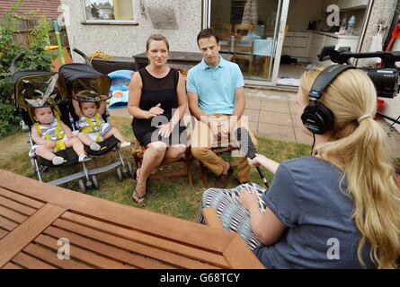 Angela and Daniel Formosa hold their daughters (left to right) Ruby and Rosie Formosa who were conjoined at their abdomens at birth last year, then separated the day after being born at Great Ormond Street Hospital, relax before their joint first birthdays on 26th July at home in Bexleyheath in Kent. Stock Photo