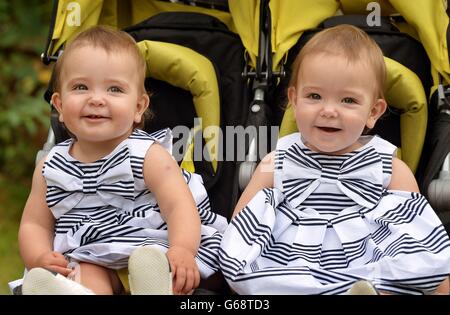 (Left to right) Ruby and Rosie Formosa who were conjoined at their abdomens at birth last year, then separated the day after being born at Great Ormond Street Hospital, relax before their joint first birthdays on 26th July at home in Bexleyheath in Kent. Stock Photo