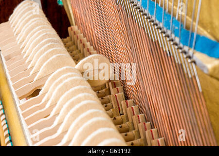 Pattern of hammers and strings inside piano, close up. One hummer in action while key is pressed. Stand out from the crowd conce Stock Photo