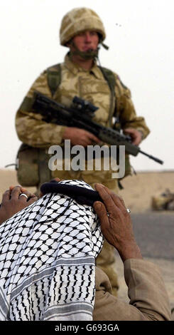 Soldiers from the Household Cavalry stop suspected Iraqi soldiers at a checkpoint in southern Iraq. Stock Photo