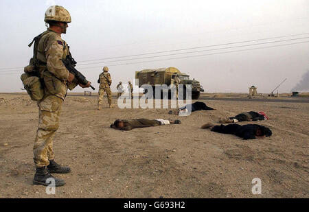 Soldiers from the Household Cavalry stop suspected Iraqi soldiers at a checkpoint in southern Iraq. Stock Photo