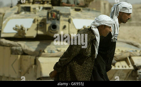 Iraqi civilians pass by a British Challanger II at a checkpoint near Basra. Photo by Dan Chung, The Guardian, MOD Pool Stock Photo