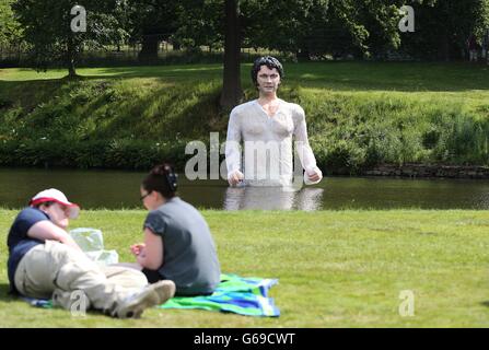 People enjoy the hot weather in front of a statue of Jane Austen's romantic hero Mr Darcy emerging from a lake in Lyme Park, Manchester. PRESS ASSOCIATION Photo. Picture date: Saturday July 20, 2013. Photo credit should read: Lynne Cameron/PA Wire Stock Photo