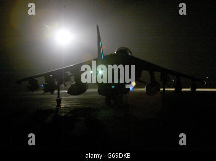 A fully armed British (RAF) Royal Air Force Harrier GR7 taxis out to the runway under spotlights at its base in Kuwait before a mission over Iraq. * U.S. and British troops moved into forward positions on Wednesday, ready to unleash a massive assault on Iraq as time ticked away for President Saddam Hussein to avoid war by choosing exile. Stock Photo