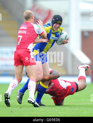 Warrington Wolves' Chris Hill is tackled by Hull Kingston Rovers' Michael Dobson (left) and Michey Paea during the Super League match at the Halliwell Jones Stadium, Warrington. Stock Photo