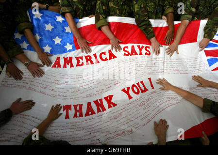 British Royal Air Force Harrier GR7 ground crew hold a banner on their base in Kuwait. The banner was sent by the U.S. Kingman Academy Middle School from Arizona, which are sited next to the Marine AV-8B Harrier base in the States in appreciation for the work done by the Harriers over Iraq. Stock Photo