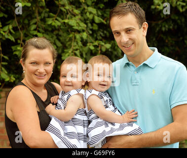 Angela and Daniel Formosa hold their daughters (left to right) Ruby and Rosie Formosa who were conjoined at their abdomens at birth last year, then separated the day after being born at Great Ormond Street Hospital, relax before their joint first birthdays on 26th July at home in Bexleyheath in Kent. Stock Photo