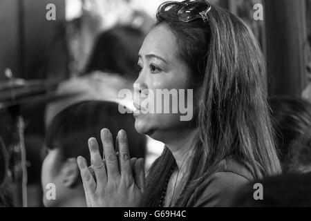 Emotional Vietnamese woman praying at a temple Stock Photo