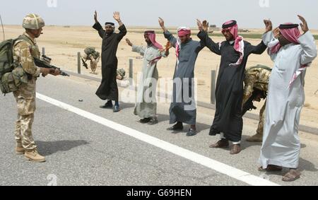 Iraqi men are frisked by soldiers of the 1st Battalion The Parachute Regiment carrying out vehicle searches for weapons in southern Iraq. * Paratroopers in Puma helicopters patrol the skies and are able to drop a platoon of men onto the road or desert track ahead of a car to facilitate the random stops. 17/10/04: The Government faced opposition demands for a Commons statement on plans to deploy British troops in support of the Americans around Baghdad. Blair was warned that British forces in Iraq could face a dangerous backlash if US attempts to seize the insurgent stronghold of Fallujah Stock Photo