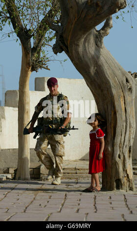 A soldier from C company of the 1st Battalion The Parachute Regiment patrols past 'Adam's tree' (right) in the biblical Garden of Eden in Al Qurna, Iraq. It is the first time the British army has patrolled on foot wearing berets and not helmets. Stock Photo