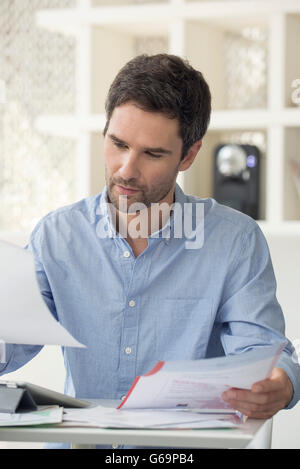 Man looking through monthly bills Stock Photo
