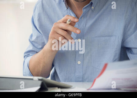 Using digital tablet to manage paperwork Stock Photo