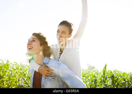 Man giving girlfriend piggyback ride Stock Photo