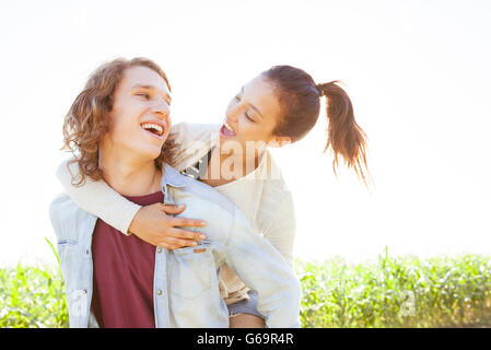 Man giving girlfriend piggyback ride Stock Photo