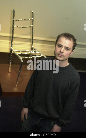 Jochen Holz stands in front of his piece 'Who Sat on my Chair?', at the Great Eastern Hotel, London. The exhibition, which runs between March 30 to April 20, is called Art of the Impossible and features work by postgraduate students from the Royal College of Art. Stock Photo