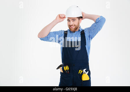 Portrait of happy bearded young builder in overall and helmet Stock Photo